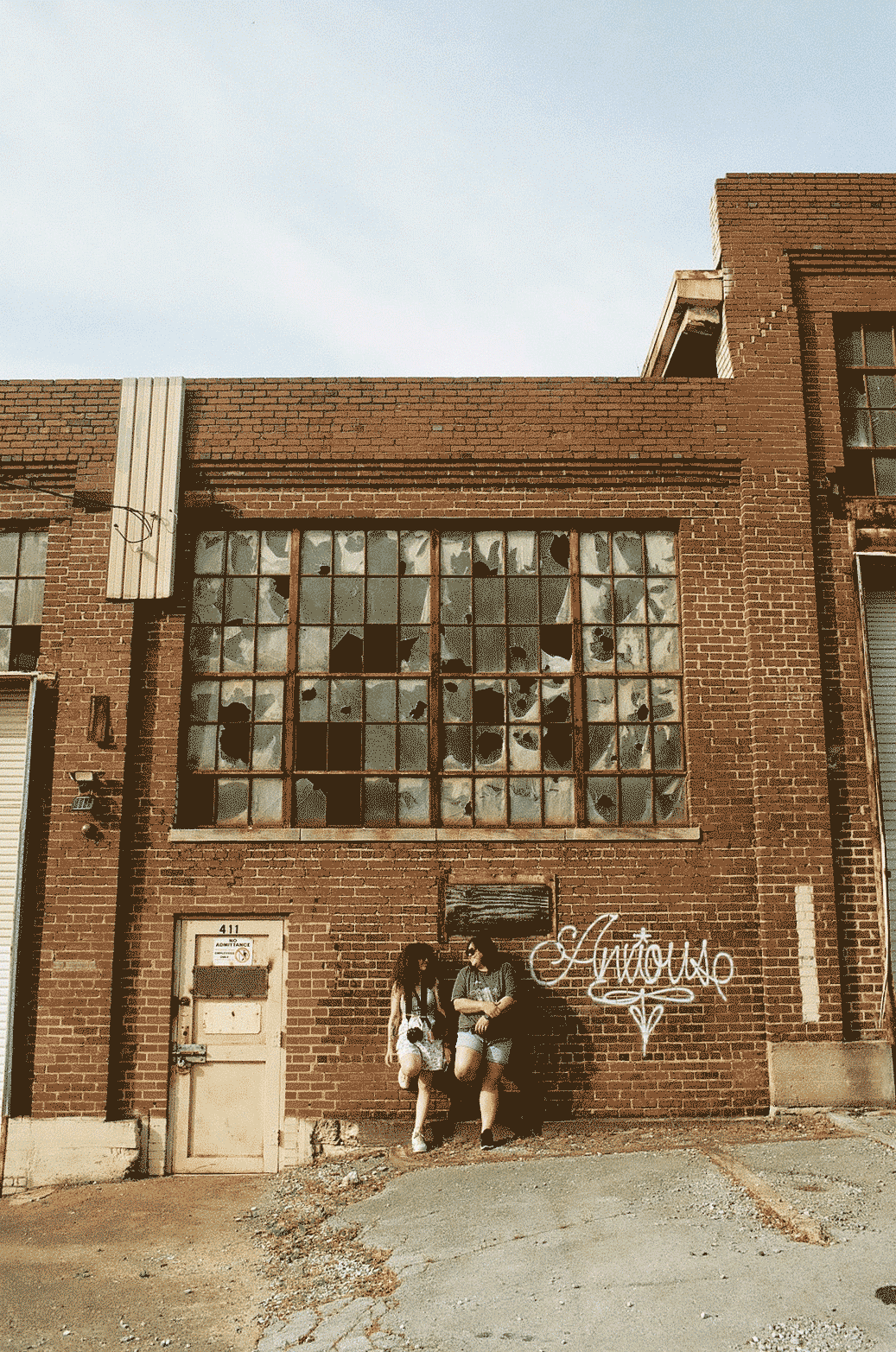 Decayed building with two people leaning against it looking at each other